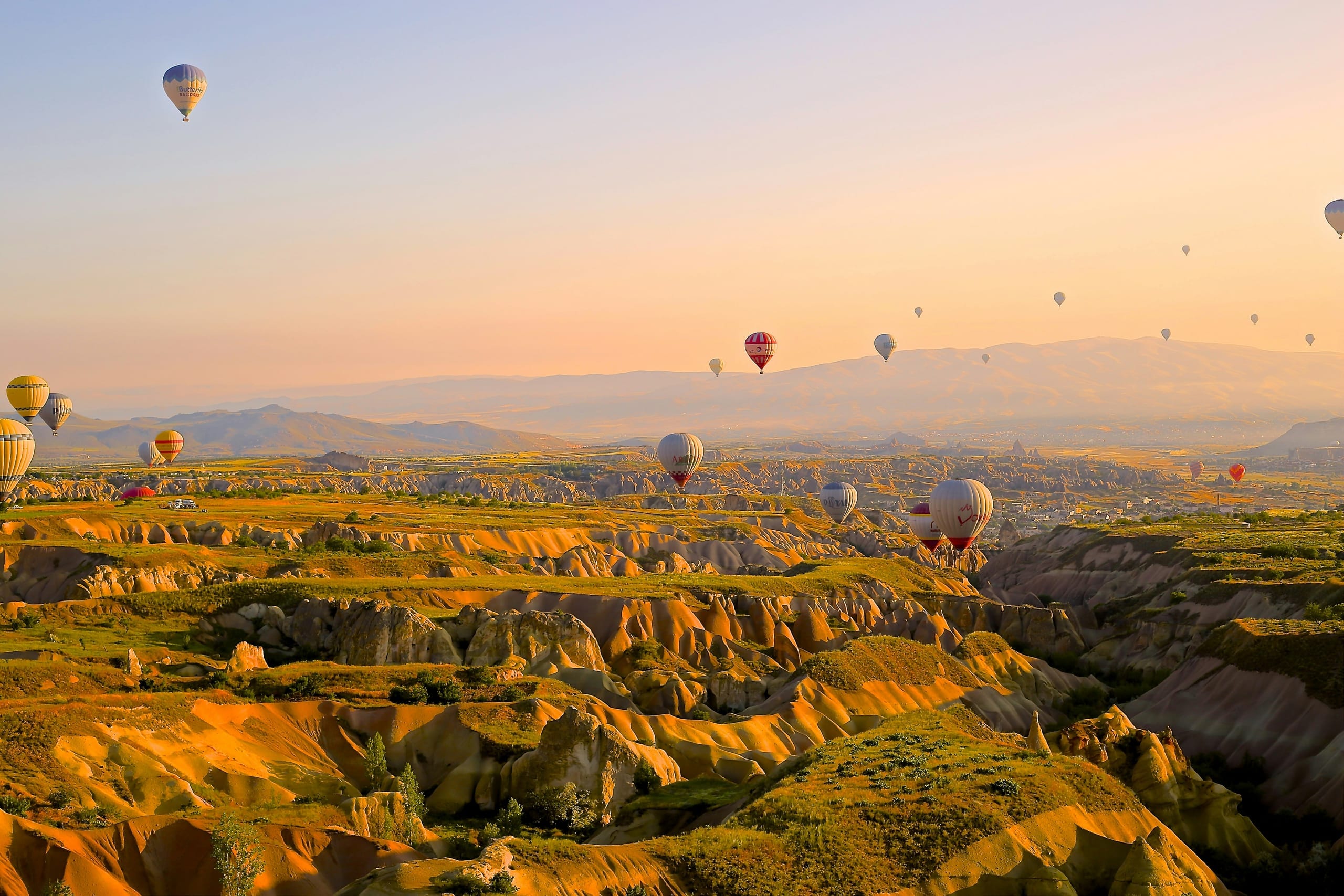 Hot-air balloons drifting over Cappadocia at sunrise