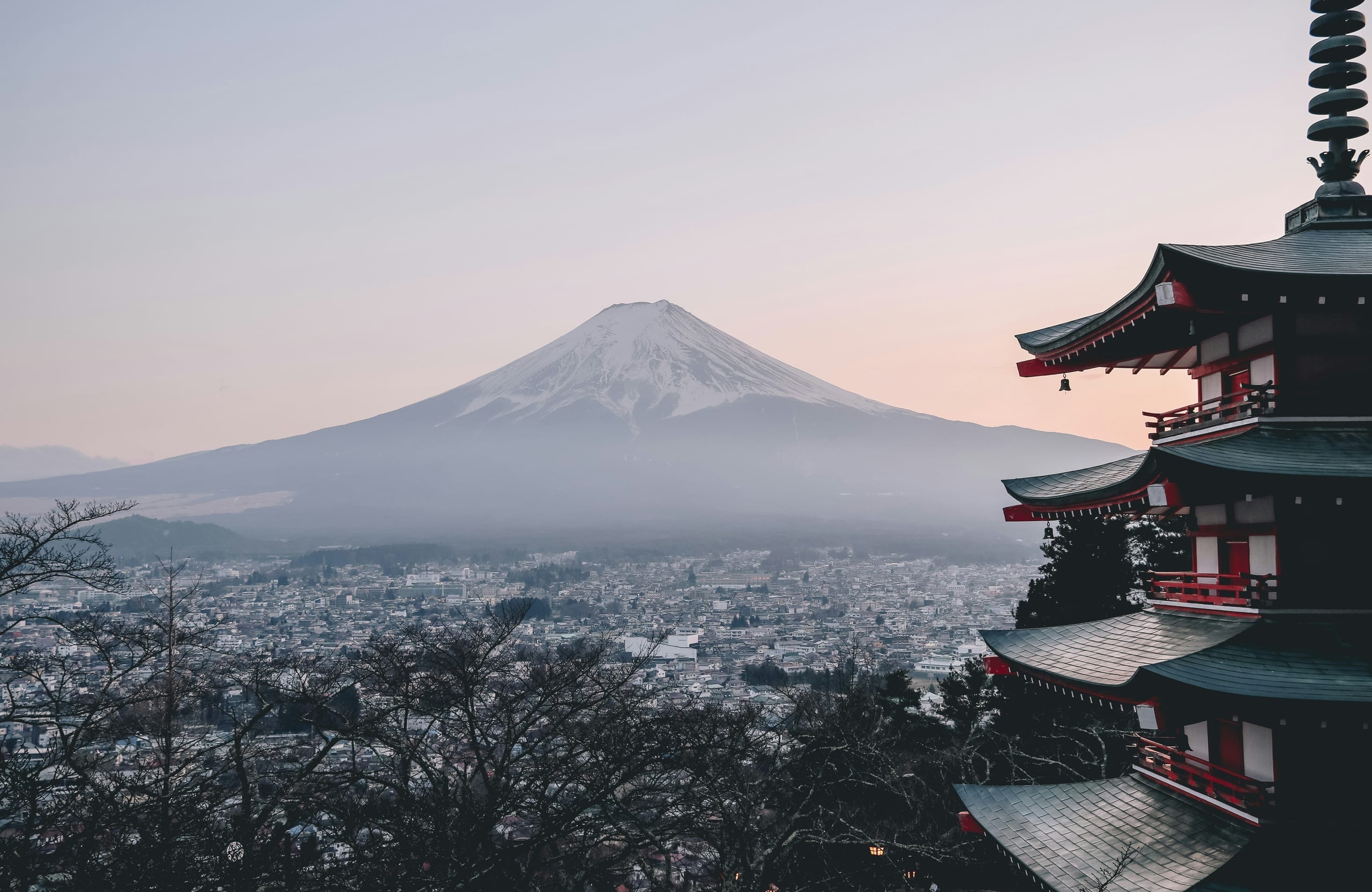 Mount Fuji at dawn beyond a red pagoda