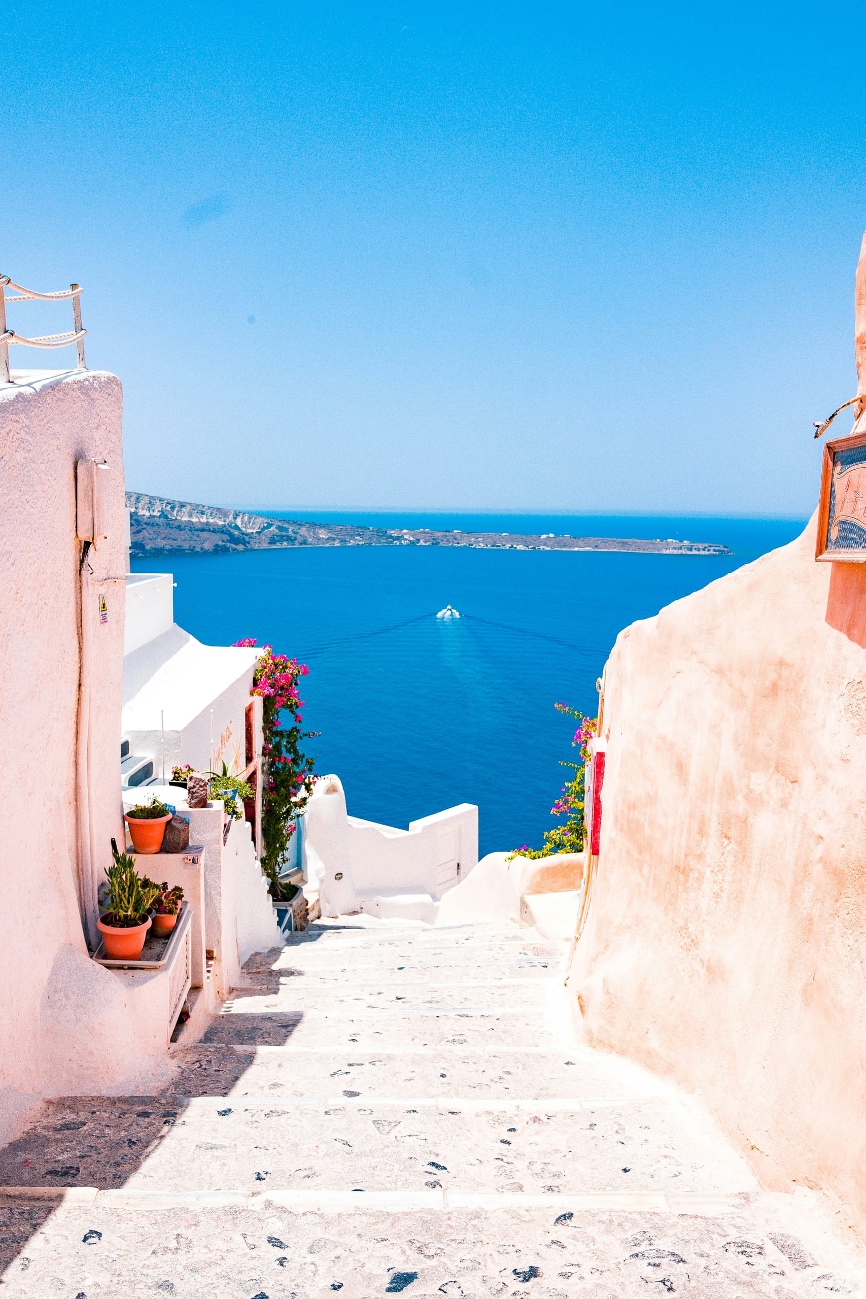 A whitewashed stepped alley leading down to the sea in Santorini